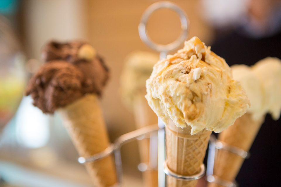 Filled cones upright in a wire rack, one chocolate and one pale yellow cream marbled with darker swirls