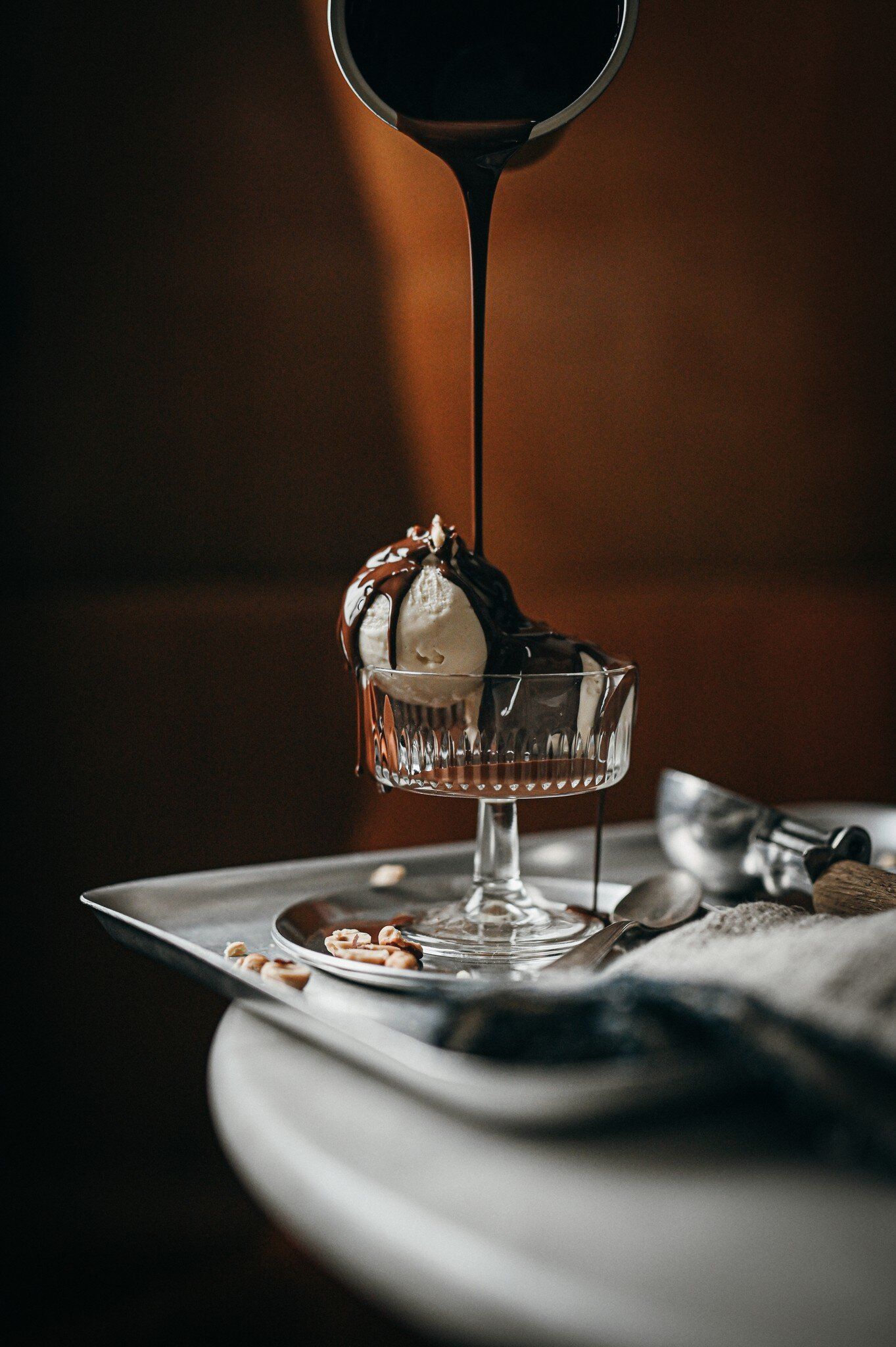 Espresso being poured from a jug over a scoop of ice cream in a stemmed glass