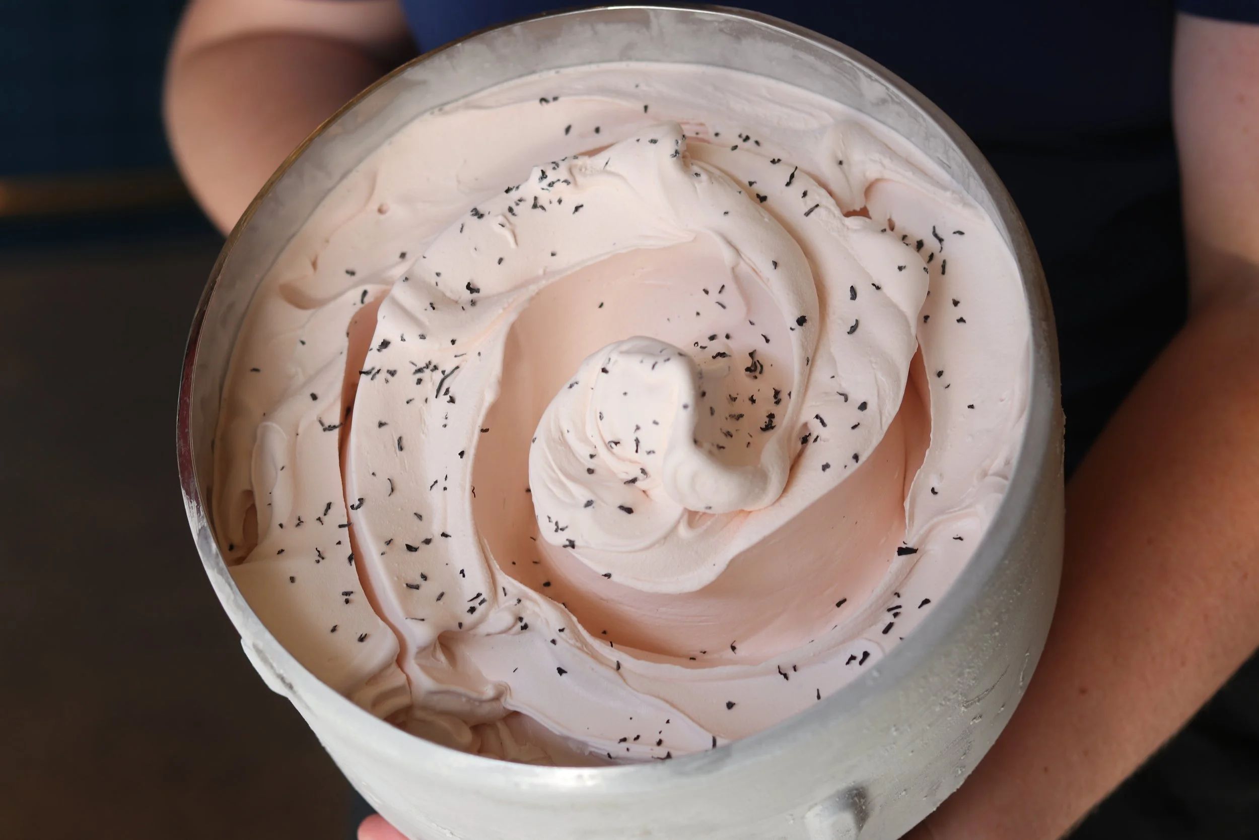 A tub of pale swirled gelato flecked dark through the surface