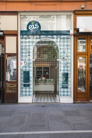 A tiled shopfront under a blue sign reading eis, seen from across the street