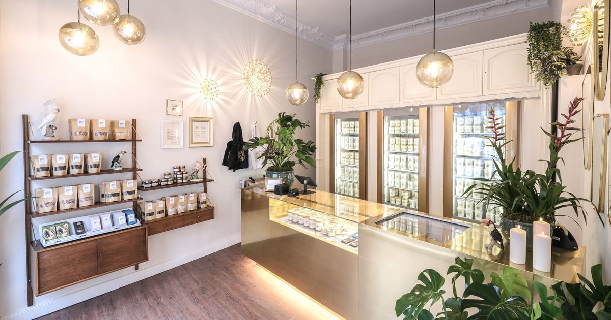 The shop interior, pale and lit from above, with a long chilled display case down one side and shelves of jars behind