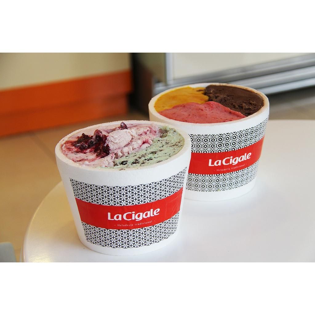Two La Cigale tubs side by side on a counter, one filled with pistachio and berry, one with three flavours