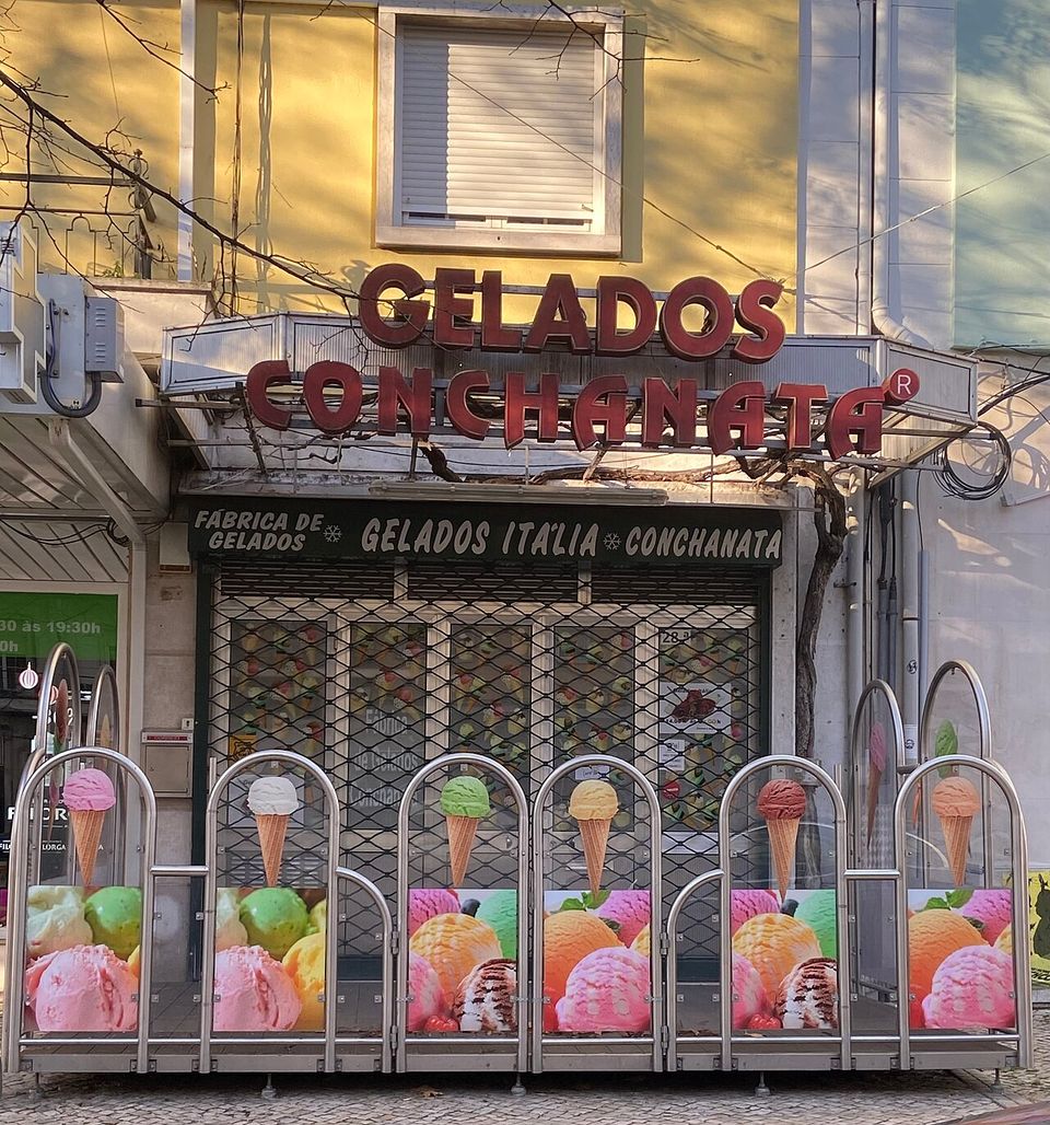 Tall red letters spelling GELADOS CONCHANATA above a shuttered shopfront, a row of chrome arches below printed with scoops