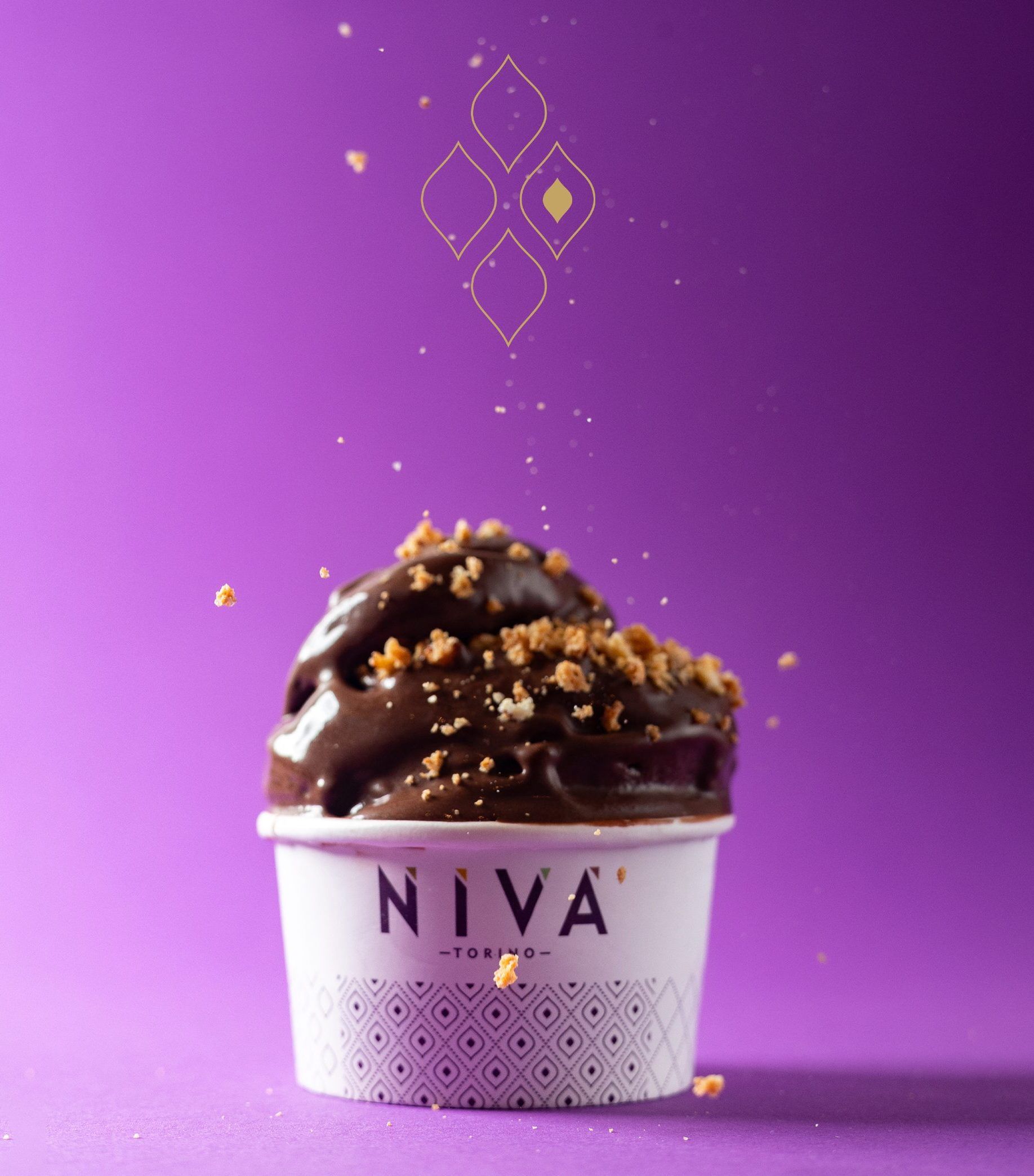 A branded cup of gelato under a chocolate topping, against violet