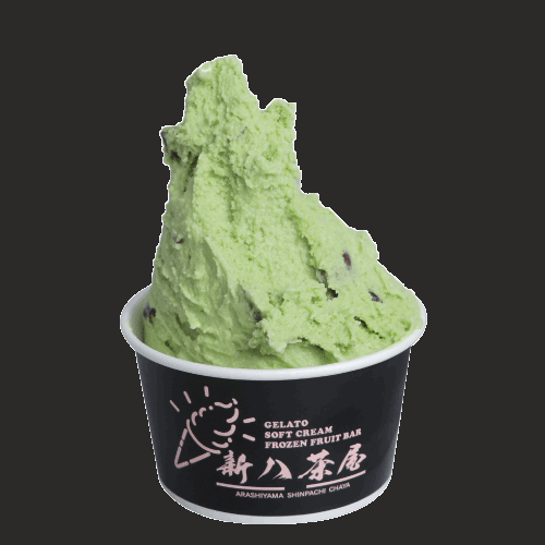 A swirl of matcha soft serve topped with red bean in a black cup branded Arashiyama Shinpachi Chaya